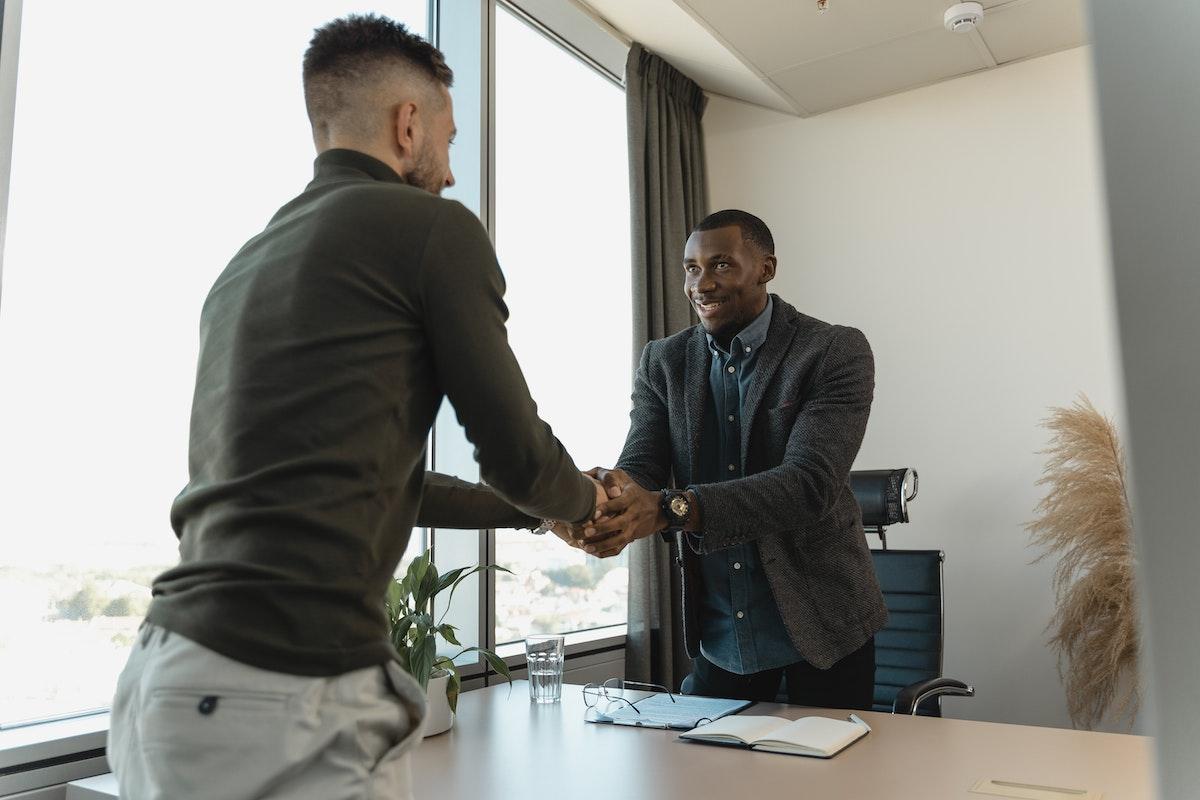 A man shaking the hands of a recruiter after a job interview.